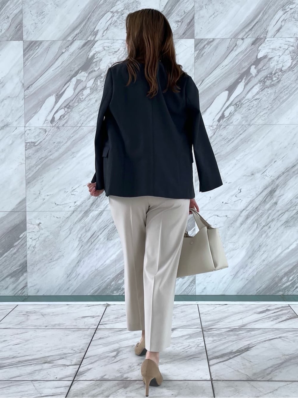 オレンジ系のシャツ/ブラウス、ベージュ系のその他パンツ、ホワイト系のショルダーバッグを着用したレディースの春コーディネートの6枚目の写真