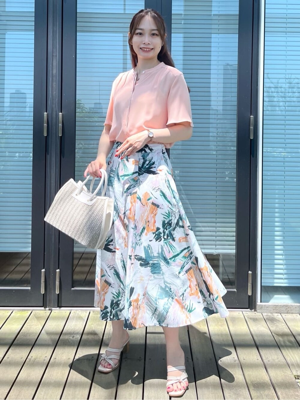オレンジ系のシャツ/ブラウスを着用したレディースの夏コーディネートの2枚目の写真