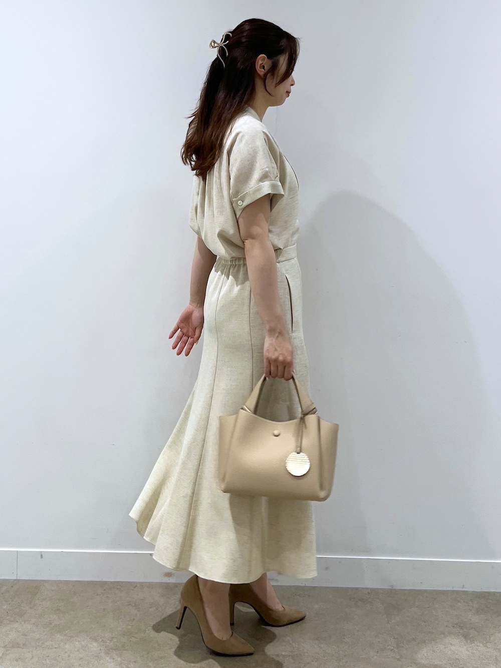 ベージュ系のシャツ/ブラウス、ベージュ系のスカート、ベージュ系のショルダーバッグを着用したレディースの春コーディネートの2枚目の写真