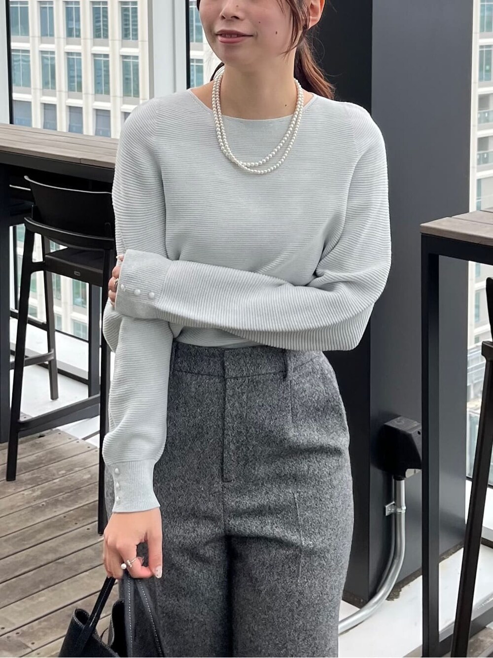 グレー系のニット/セーター、ブラック系のその他パンツ、ブラック系のトートバッグを着用したレディースの冬コーディネートの6枚目の写真
