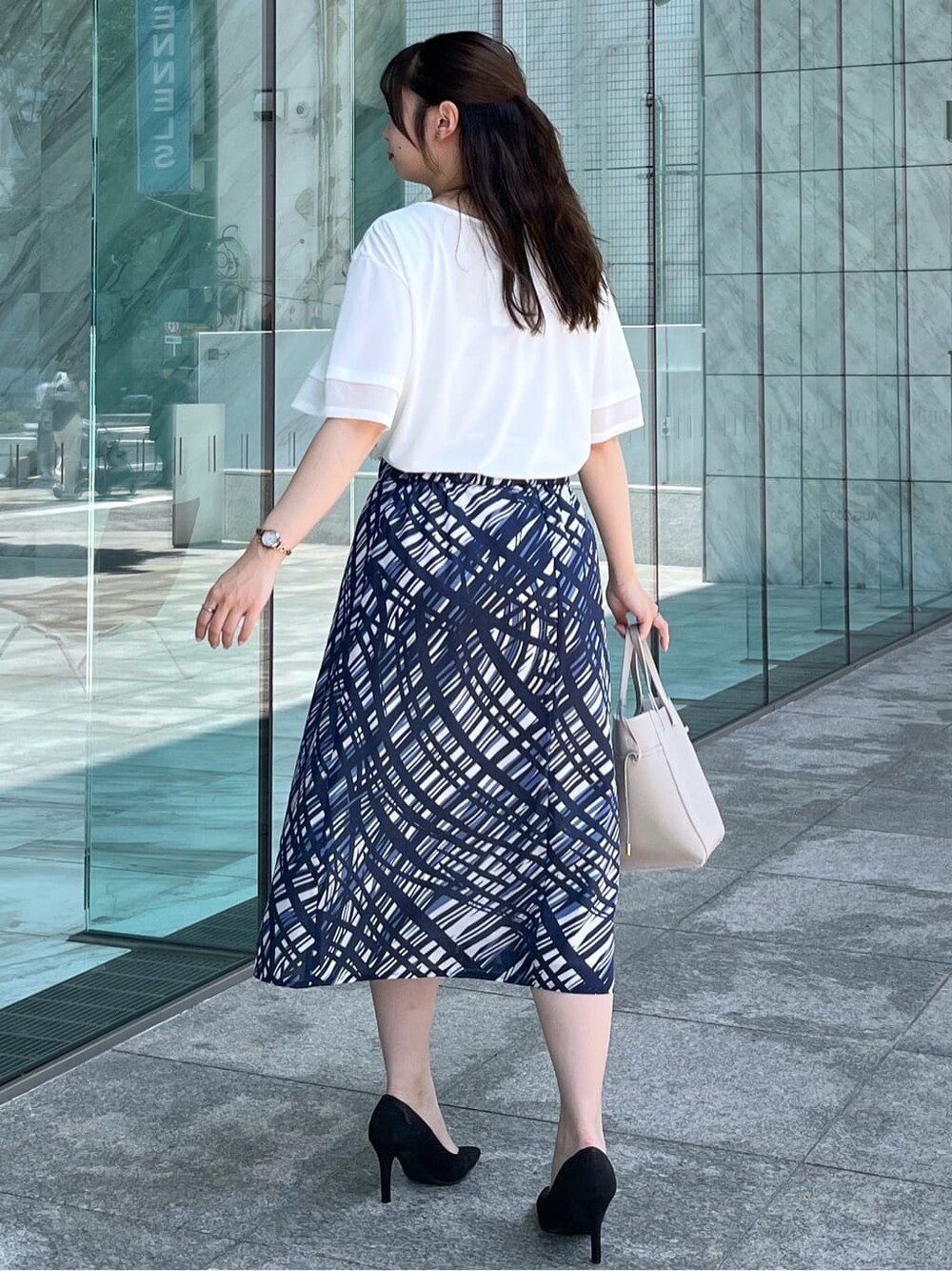 ホワイト系のTシャツ/カットソー、ブルー系のスカート、グレー系のトートバッグを着用したレディースの夏コーディネートの5枚目の写真