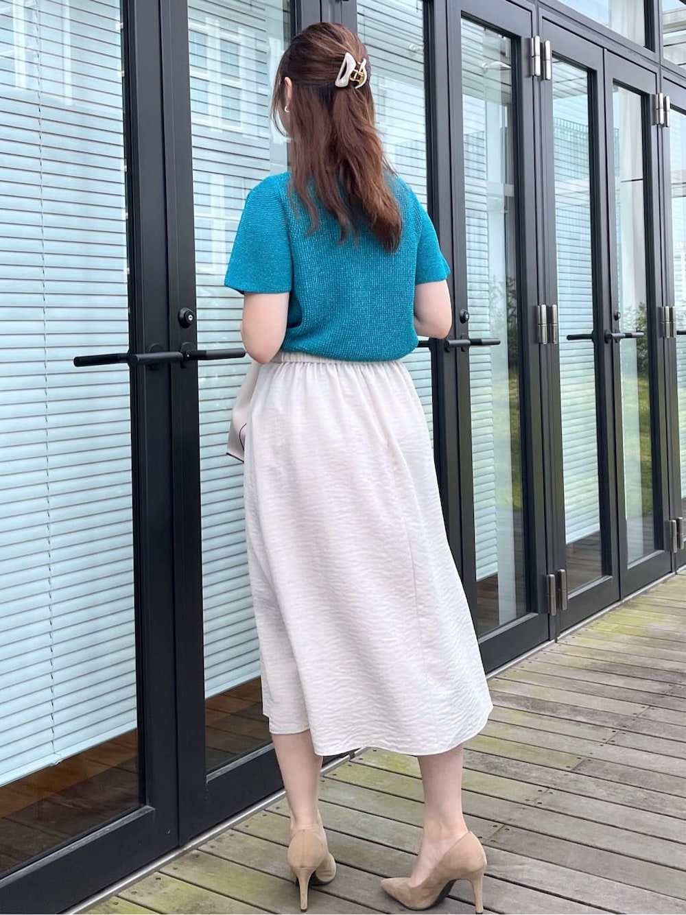 ブルー系のニット/セーター、グレー系のスカート、グレー系のトートバッグを着用したレディースの夏コーディネートの6枚目の写真