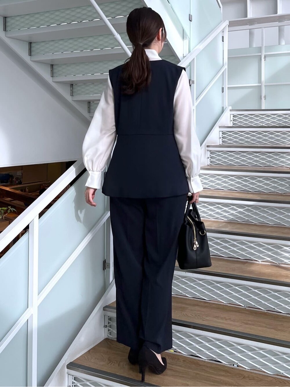 ブルー系のベスト、ブルー系のその他パンツ、ホワイト系のシャツ/ブラウスを着用したレディースの冬コーディネートの6枚目の写真