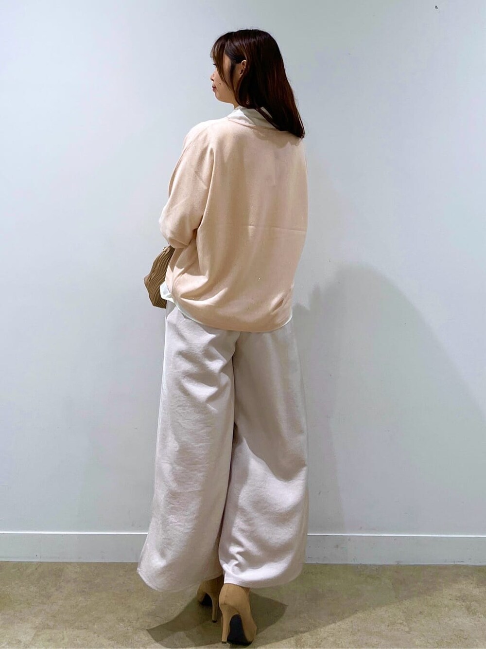 ベージュ系のニット/セーター、ホワイト系のシャツ/ブラウス、ブラック系のその他パンツを着用したレディースの秋コーディネートの7枚目の写真