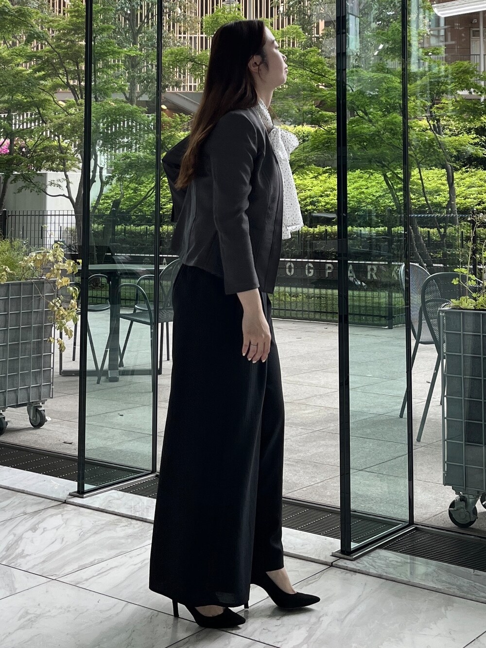 ブラック系のその他パンツ、ホワイト系のシャツ/ブラウス、ブルー系のノーカラージャケットを着用したレディースの春コーディネートの3枚目の写真