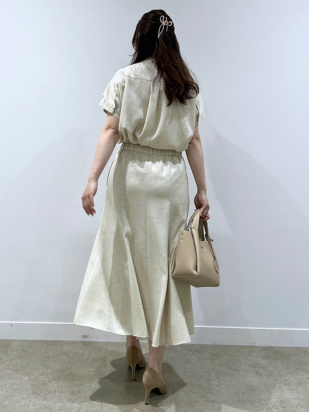 ベージュ系のシャツ/ブラウス、ベージュ系のスカート、ベージュ系のショルダーバッグを着用したレディースの春コーディネートの3枚目の写真