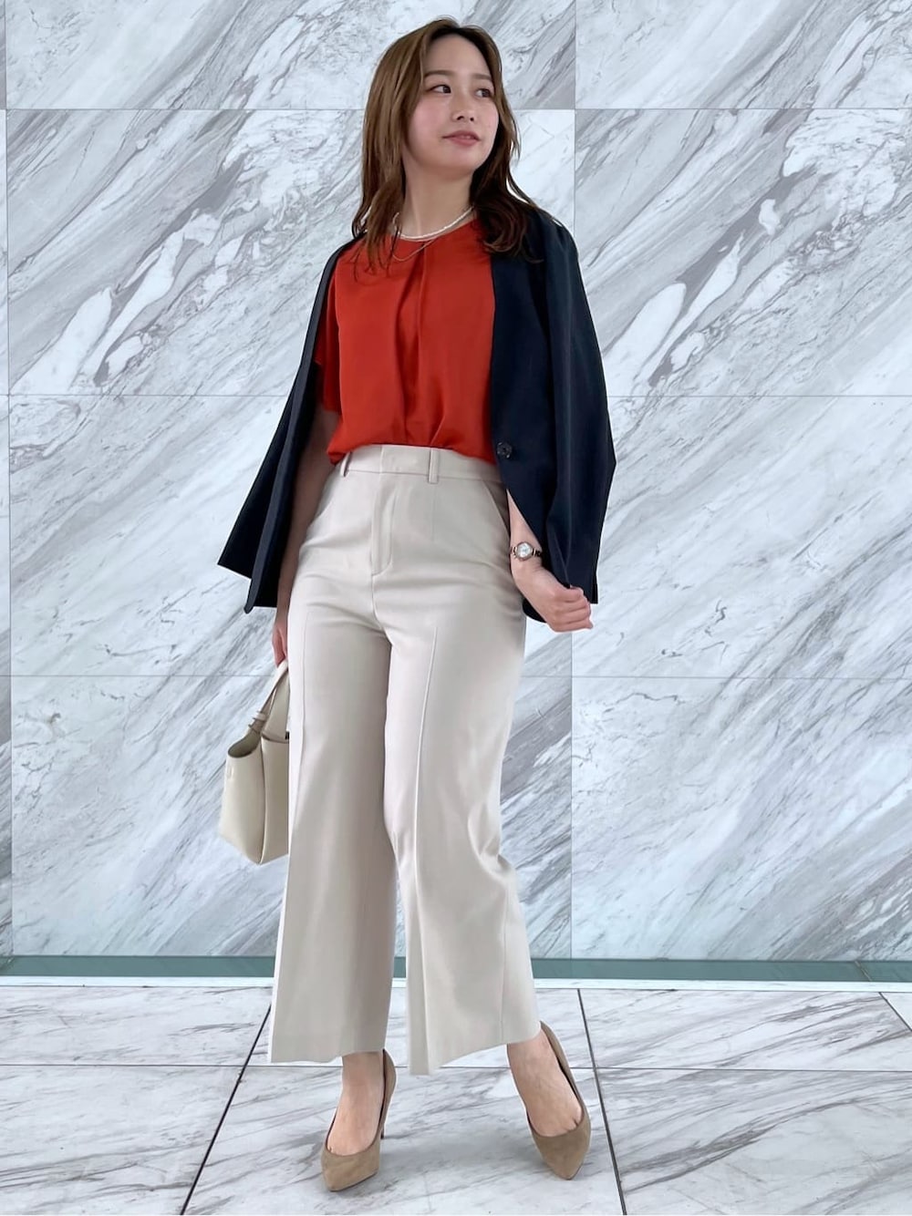 オレンジ系のシャツ/ブラウス、ベージュ系のその他パンツ、ホワイト系のショルダーバッグを着用したレディースの春コーディネートの2枚目の写真