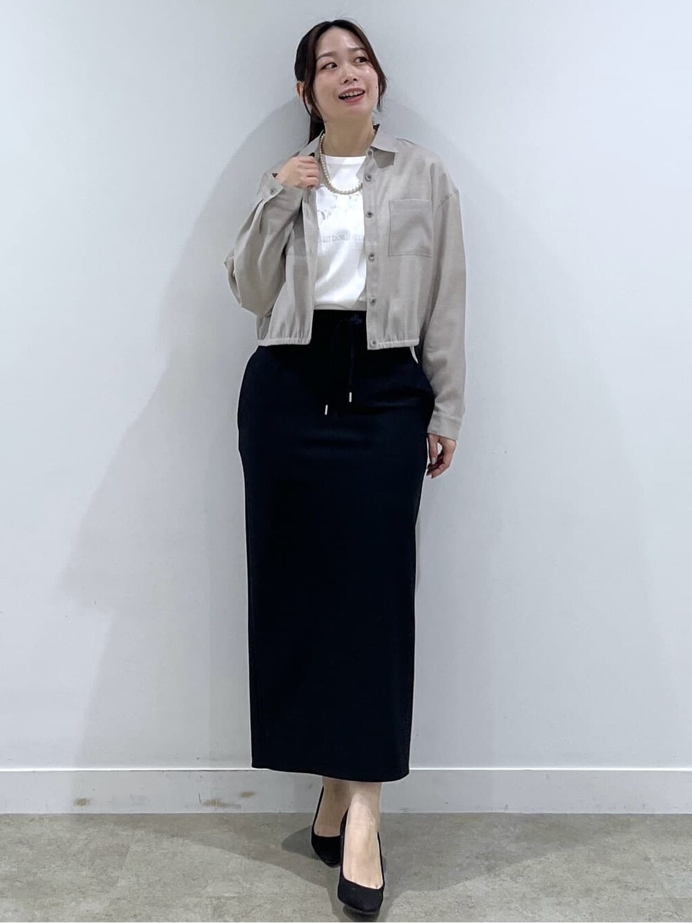ベージュ系のシャツ/ブラウス、ホワイト系のTシャツ/カットソー、ブラック系のスカートを着用したレディースの春コーディネートの2枚目の写真