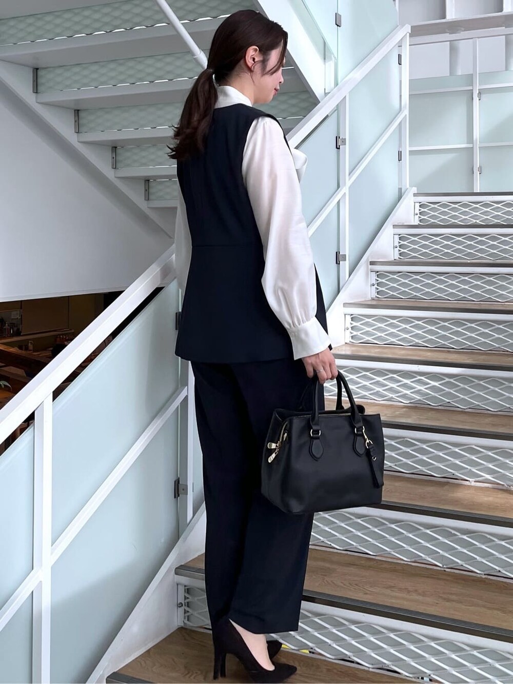 ブルー系のベスト、ブルー系のその他パンツ、ホワイト系のシャツ/ブラウスを着用したレディースの冬コーディネートの5枚目の写真