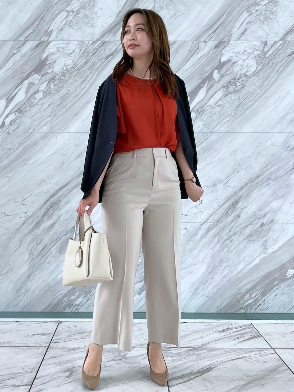 オレンジ系のシャツ/ブラウス、ベージュ系のその他パンツ、ホワイト系のショルダーバッグを着用したレディースの春コーディネートの3枚目の写真