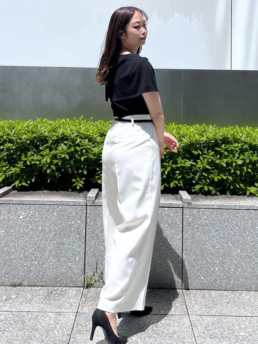 ブラック系のニット/セーター、ホワイト系のその他パンツを着用したレディースの春コーディネートの4枚目の写真