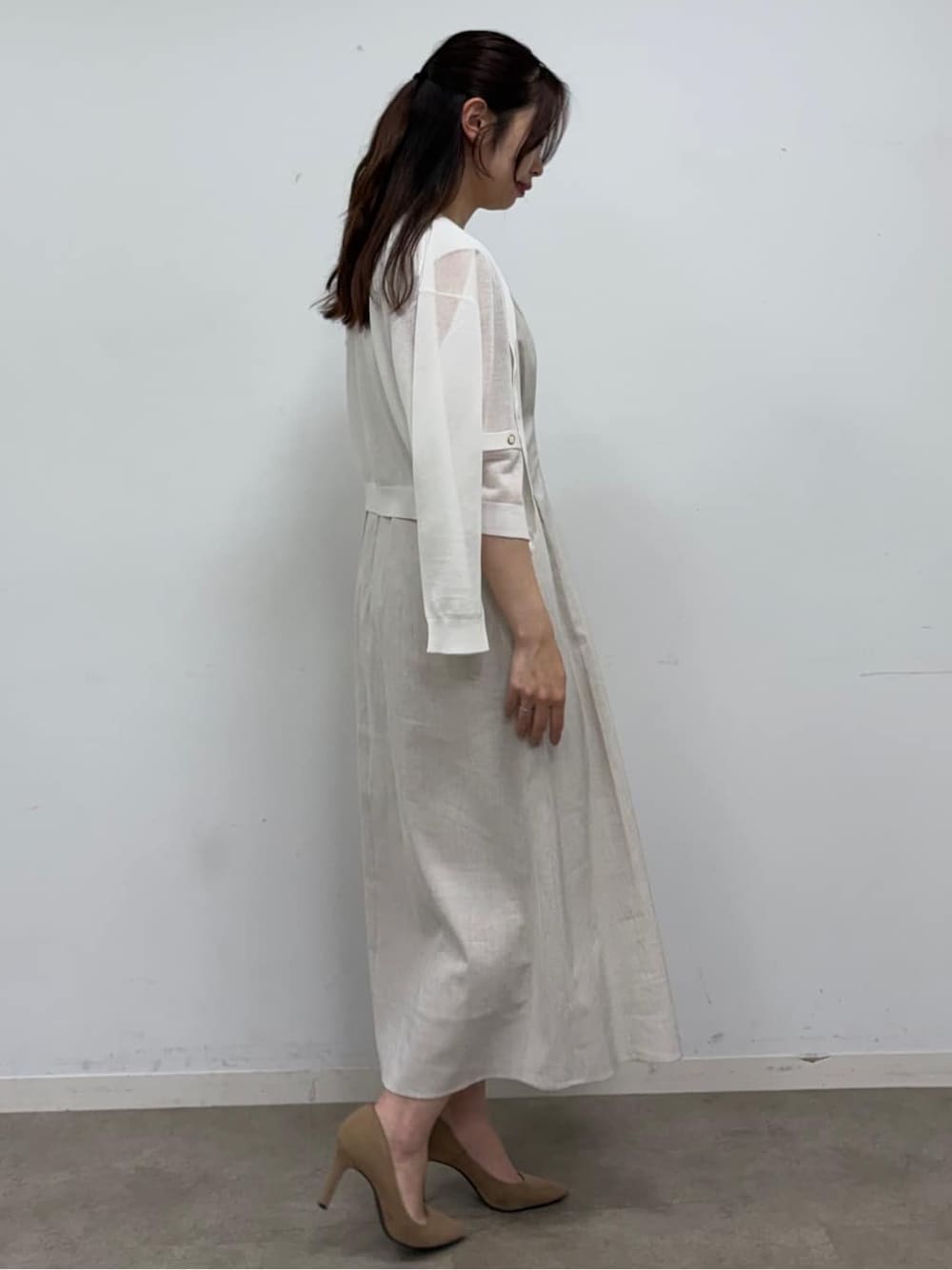 ベージュ系のワンピース、ホワイト系のカーディガン/ボレロ、ホワイト系のショルダーバッグを着用したレディースの春コーディネートの3枚目の写真