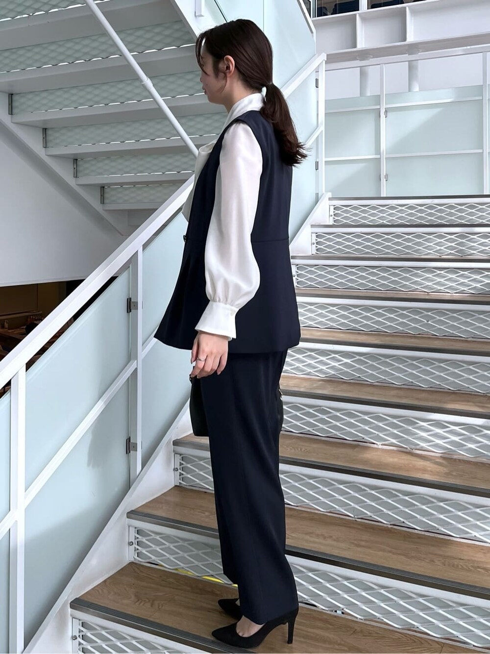 ブルー系のベスト、ブルー系のその他パンツ、ホワイト系のシャツ/ブラウスを着用したレディースの冬コーディネートの4枚目の写真