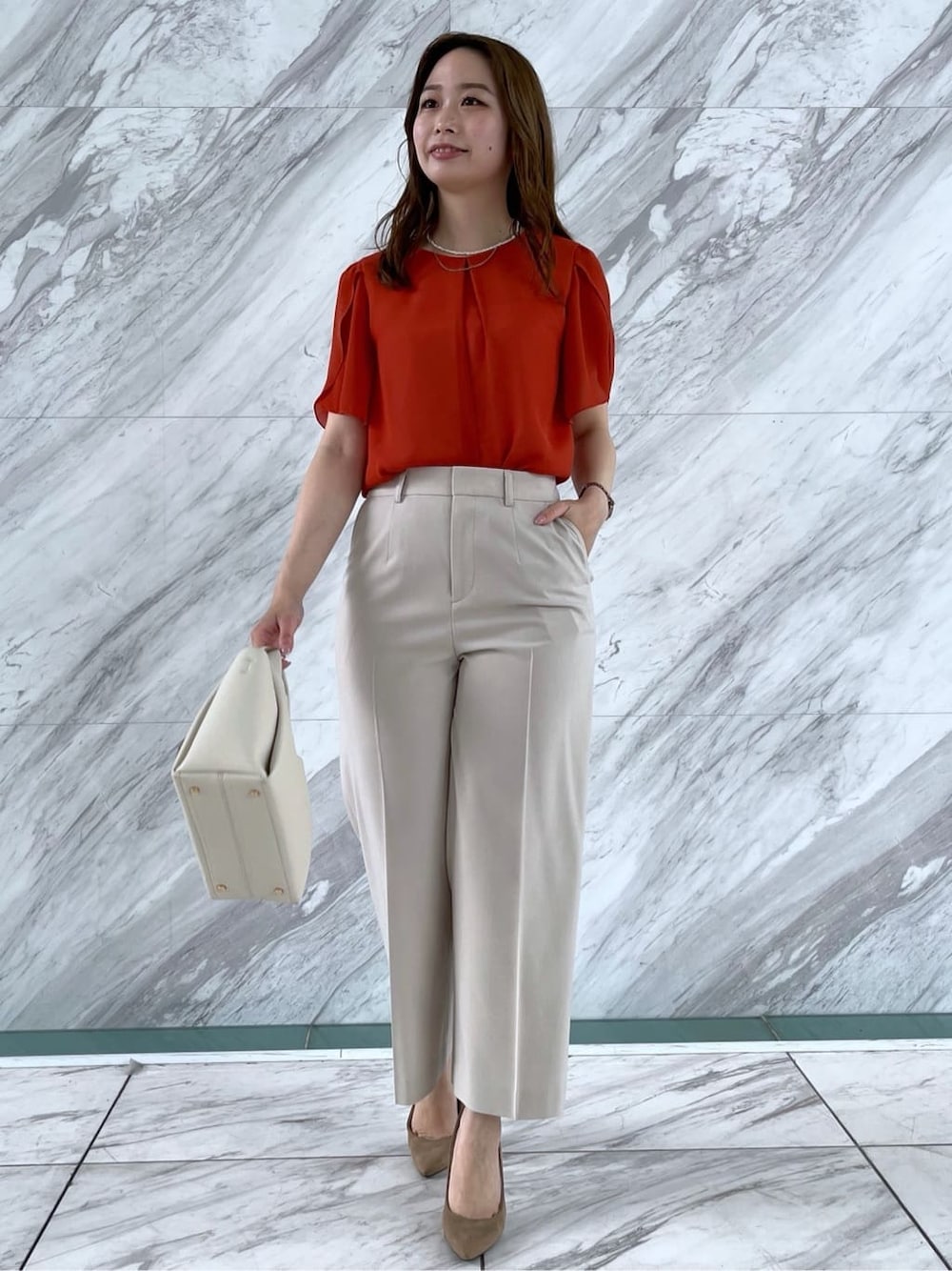 オレンジ系のシャツ/ブラウス、ベージュ系のその他パンツ、ホワイト系のショルダーバッグを着用したレディースの春コーディネートの7枚目の写真