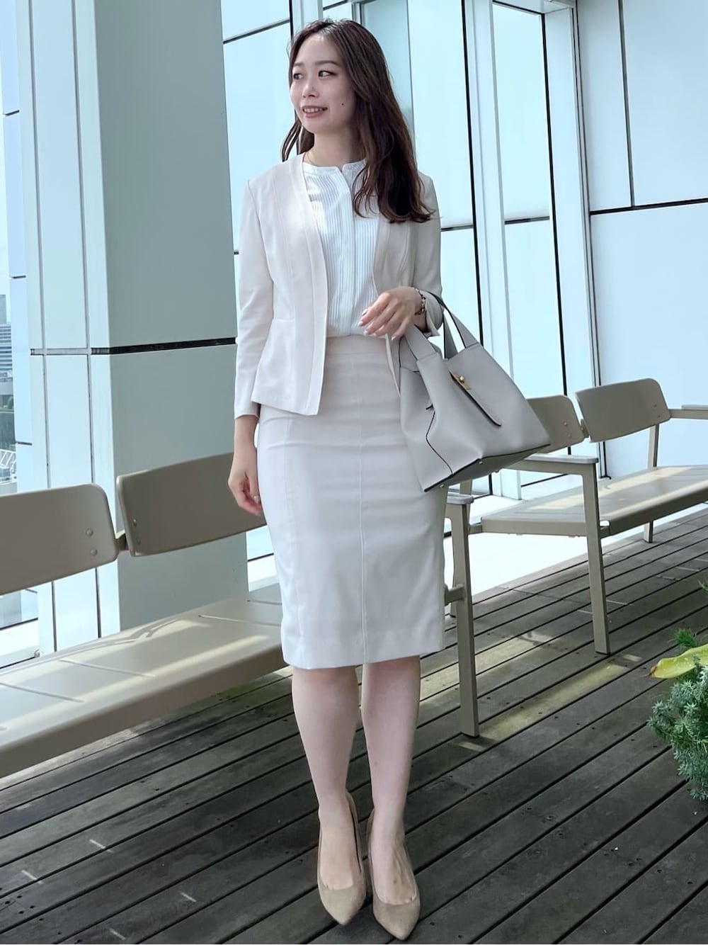 ベージュ系のノーカラージャケット、ベージュ系のスカート、ホワイト系のシャツ/ブラウスを着用したレディースの夏コーディネートの2枚目の写真