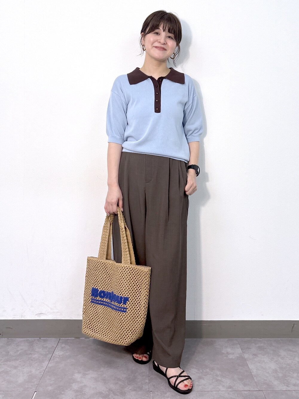 ブルー系のニット/セーター、ブラウン系のその他パンツ、ベージュ系のトートバッグを着用したレディースの夏コーディネートの2枚目の写真