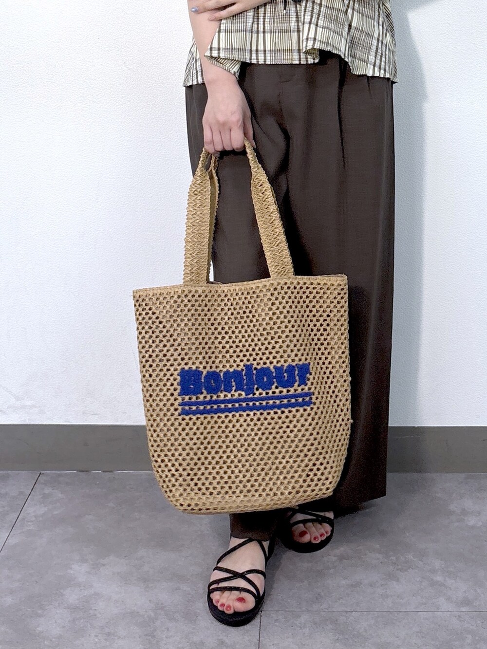 ブルー系のニット/セーター、ブラウン系のその他パンツ、ベージュ系のトートバッグを着用したレディースの夏コーディネートの6枚目の写真