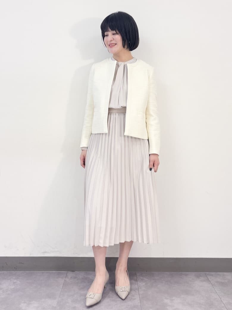 ホワイト系のノーカラージャケット、ベージュ系のワンピース、ベージュ系のパンプスを着用したレディースの冬コーディネートの2枚目の写真