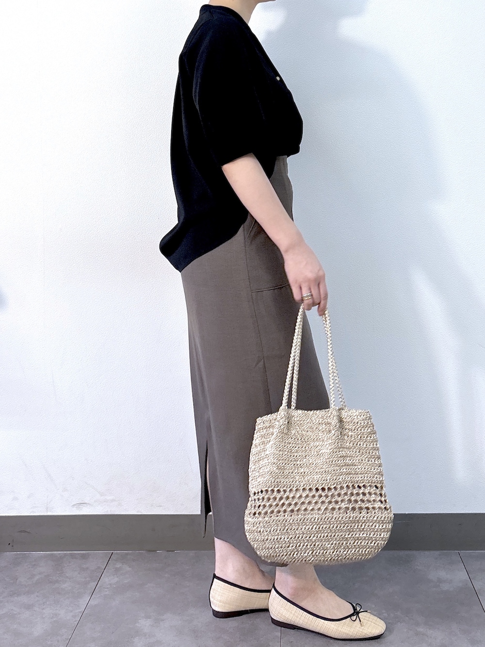 ブラック系のシャツ/ブラウス、ブラウン系のスカート、ゴールド系のトートバッグを着用したレディースの夏コーディネートの3枚目の写真