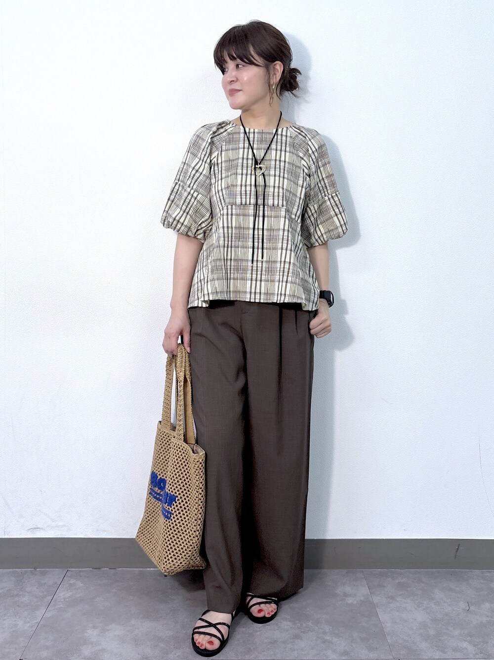 イエロー系のシャツ/ブラウス、ブラウン系のその他パンツ、ベージュ系のトートバッグを着用したレディースの夏コーディネートの3枚目の写真
