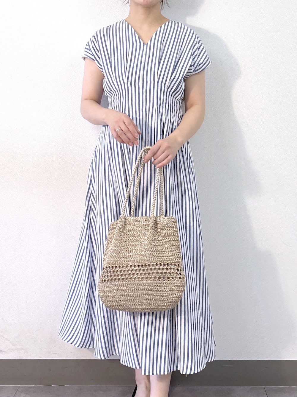 ブルー系のワンピース、ゴールド系のトートバッグ、ベージュ系のパンプスを着用したレディースの夏コーディネートの7枚目の写真