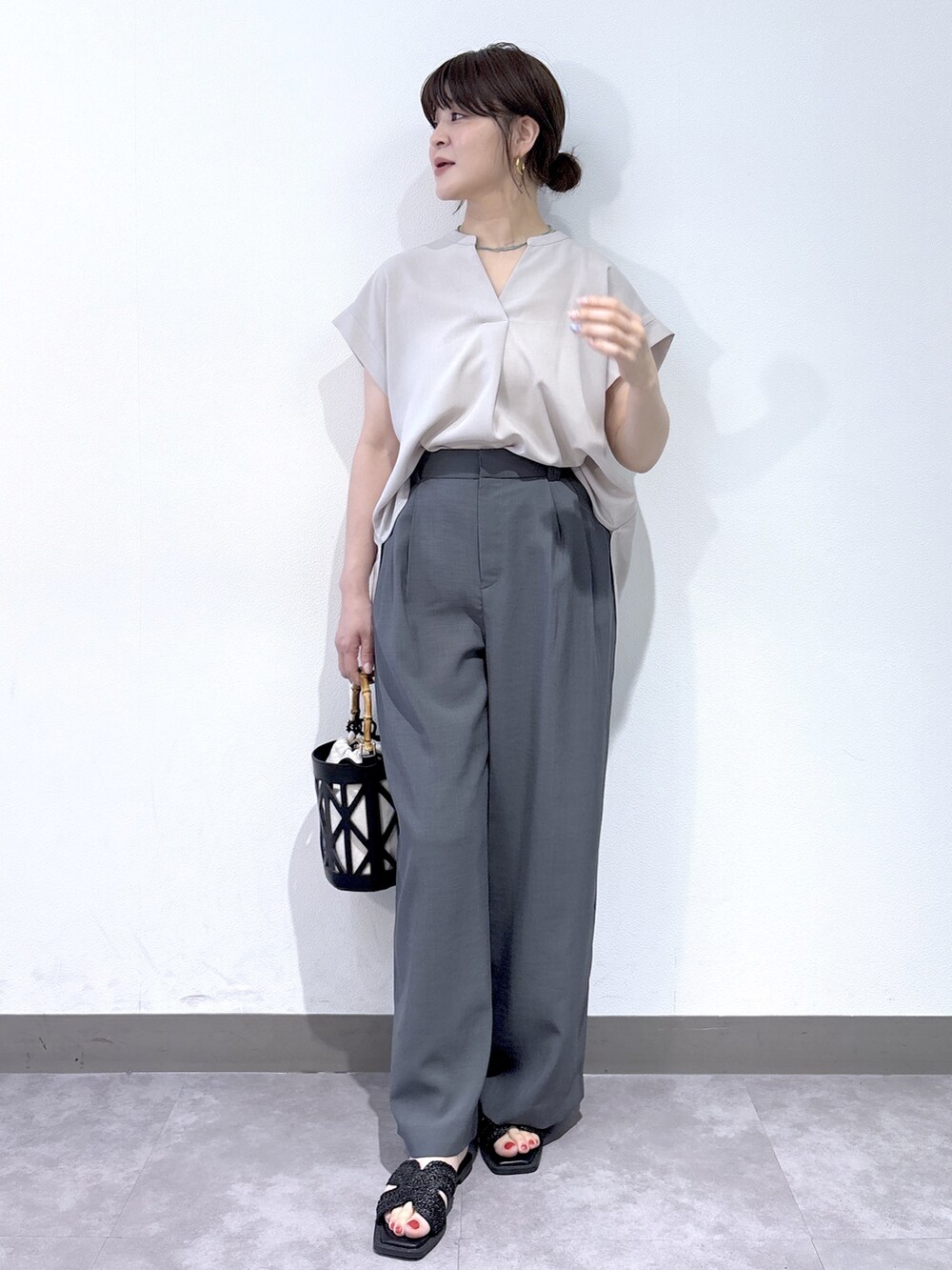 ベージュ系のシャツ/ブラウス、グレー系のその他パンツ、ブラック系のハンドバッグを着用したレディースの夏コーディネートの2枚目の写真