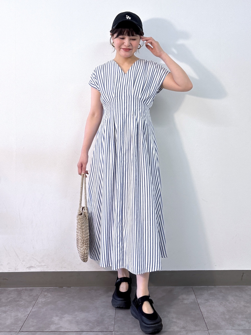 ブルー系のワンピース、ゴールド系のトートバッグを着用したレディースの夏コーディネートの4枚目の写真