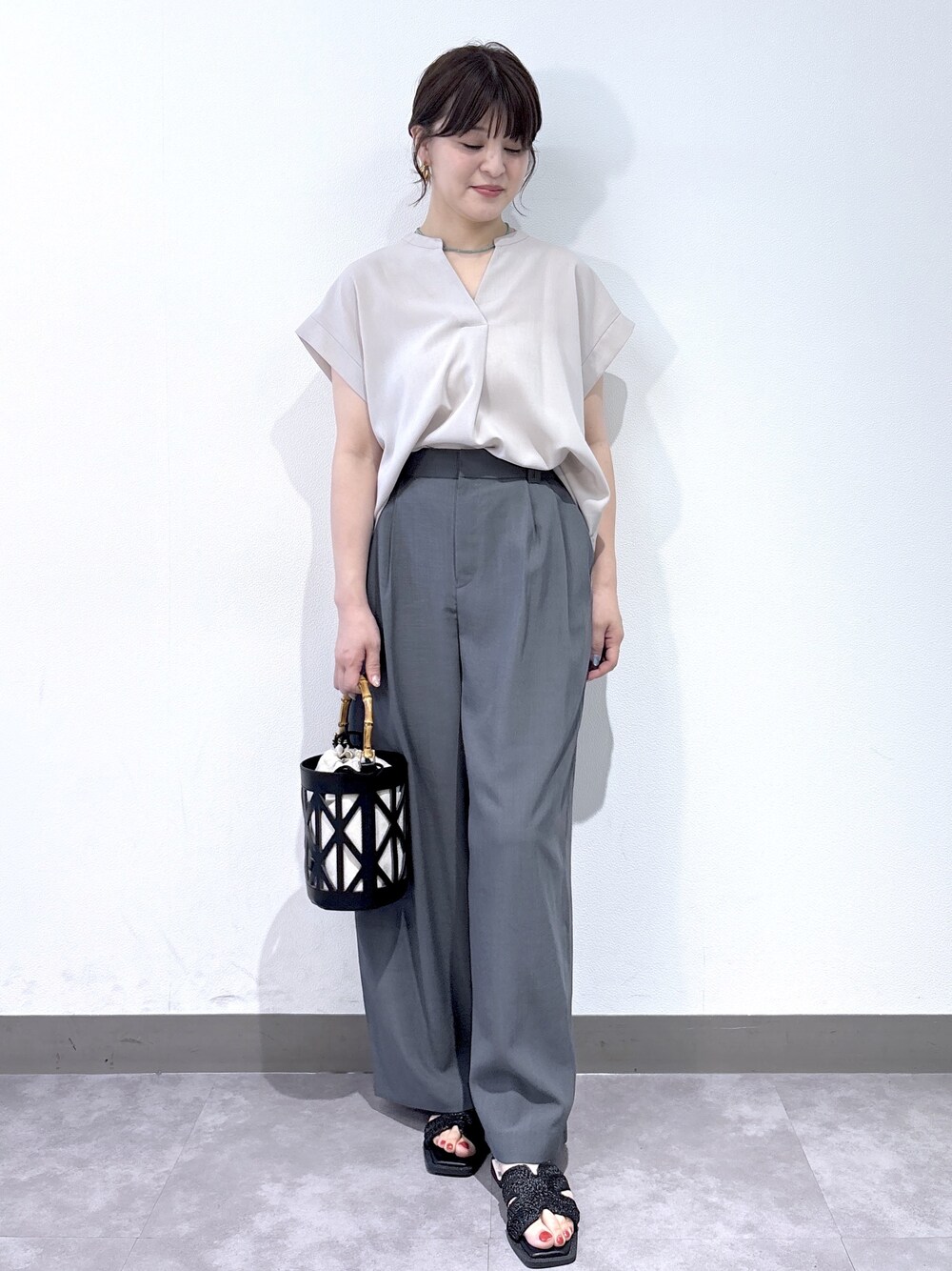 ベージュ系のシャツ/ブラウス、グレー系のその他パンツ、ブラック系のハンドバッグを着用したレディースの夏コーディネートの3枚目の写真