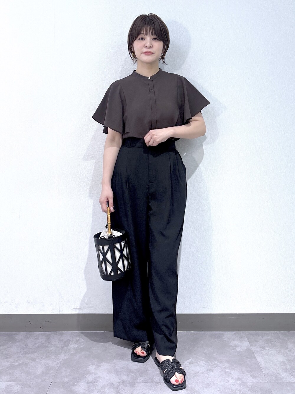 ブラウン系のシャツ/ブラウス、ブラック系のその他パンツ、ブラック系のハンドバッグを着用したレディースの夏コーディネートの3枚目の写真
