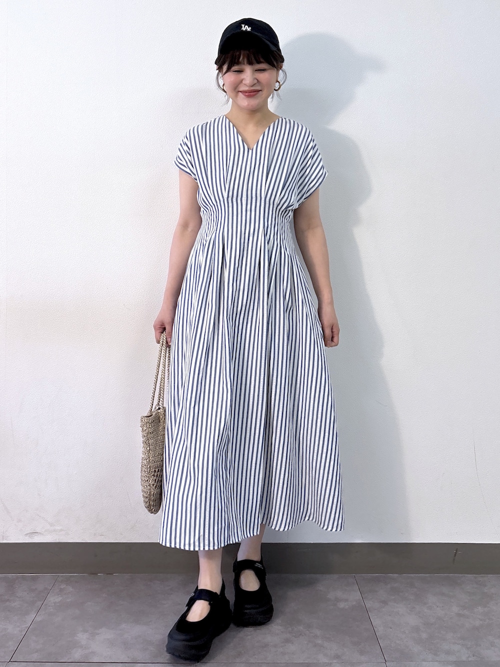 ブルー系のワンピース、ゴールド系のトートバッグを着用したレディースの夏コーディネートの2枚目の写真