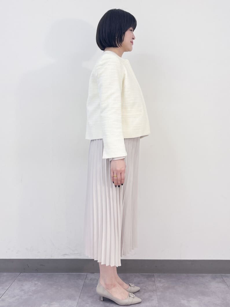 ホワイト系のノーカラージャケット、ベージュ系のワンピース、ベージュ系のパンプスを着用したレディースの冬コーディネートの4枚目の写真
