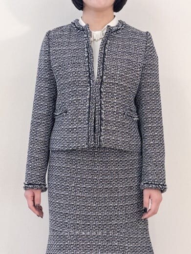 ブラック系のノーカラージャケット、ホワイト系のシャツ/ブラウス、ブラック系のスカートを着用したレディースの冬コーディネートの6枚目の写真