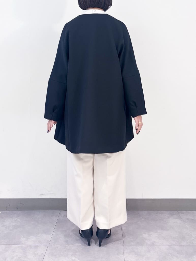 ホワイト系のノーカラーコート、ブラック系のシャツ/ブラウス、ブラック系のその他パンツを着用したレディースの冬コーディネートの7枚目の写真
