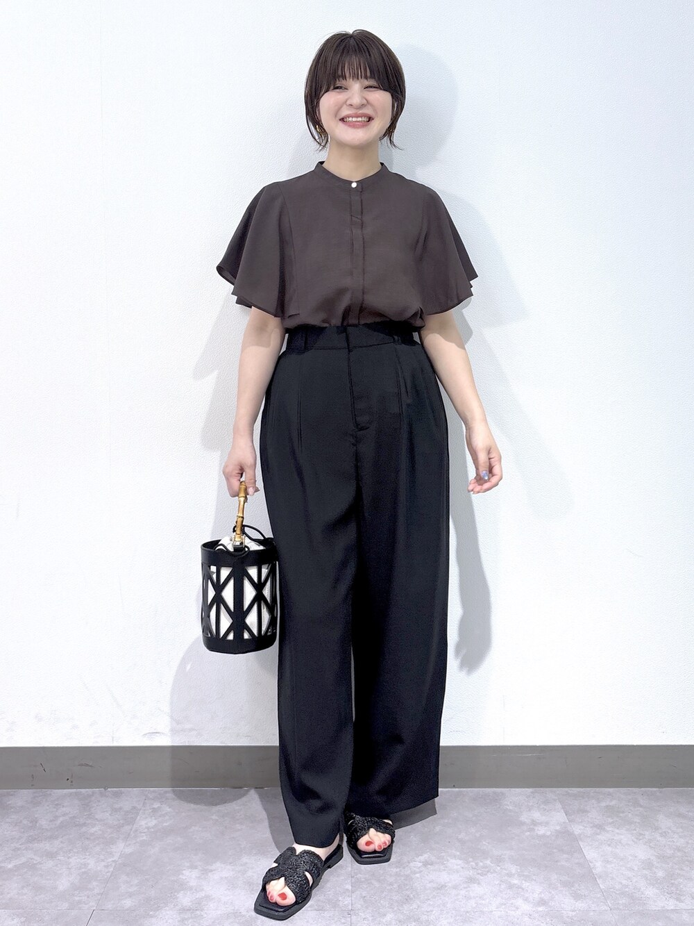 ブラウン系のシャツ/ブラウス、ブラック系のその他パンツ、ブラック系のハンドバッグを着用したレディースの夏コーディネートの2枚目の写真