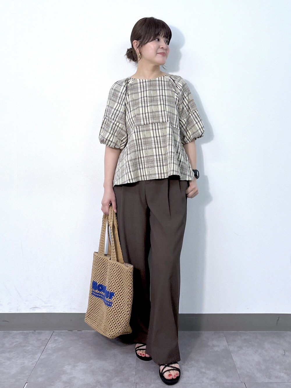 イエロー系のシャツ/ブラウス、ブラウン系のその他パンツ、ベージュ系のトートバッグを着用したレディースの夏コーディネートの2枚目の写真