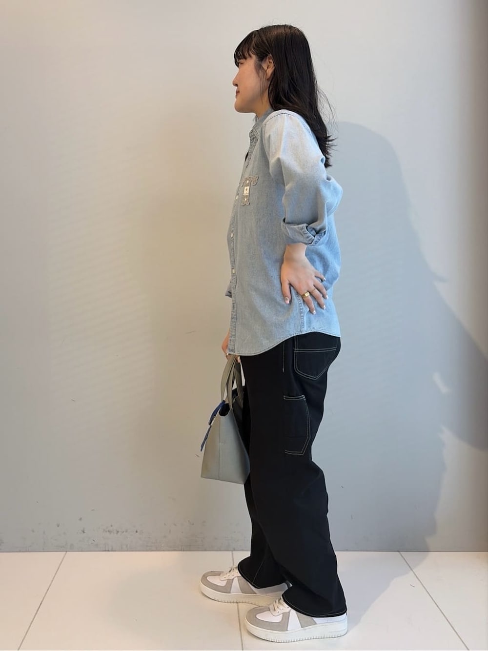 ブルー系のシャツ/ブラウス、ブラック系のデニムパンツ、ブルー系のトートバッグを着用したレディースの春コーディネートの2枚目の写真