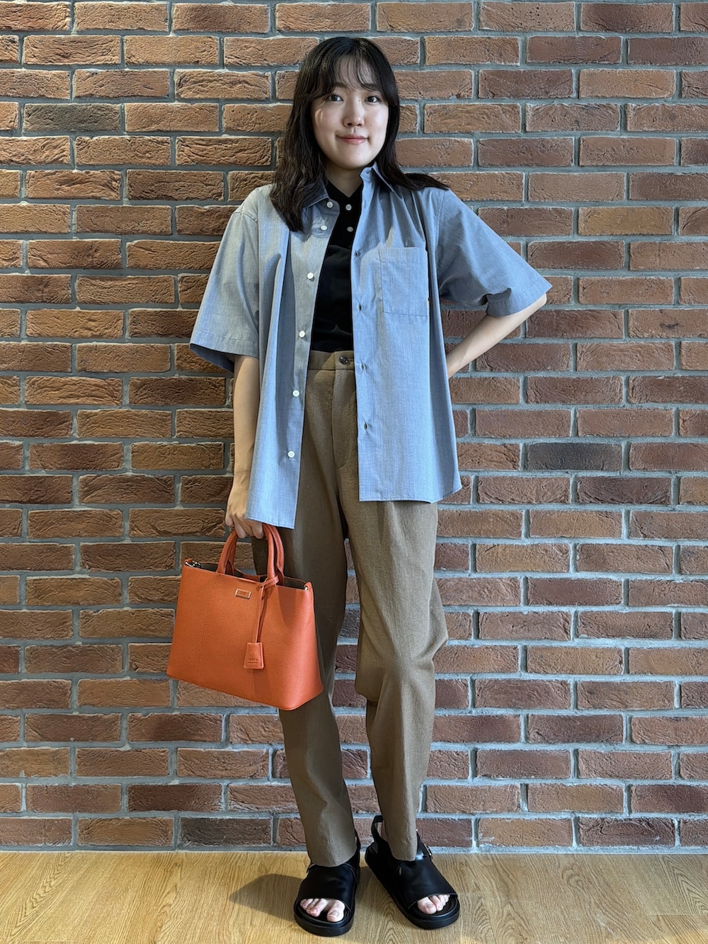 ブラック系のポロシャツ、グレー系のシャツ/ブラウス、ベージュ系のスラックスを着用したメンズの夏コーディネートの5枚目の写真