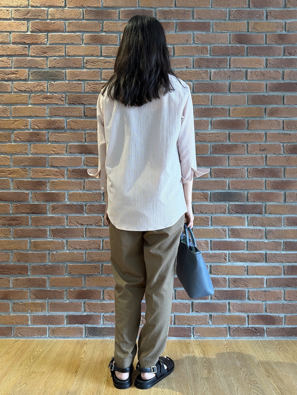 ピンク系のシャツ/ブラウス、ブラウン系のスラックス、ブルー系のトートバッグを着用したメンズの夏コーディネートの3枚目の写真