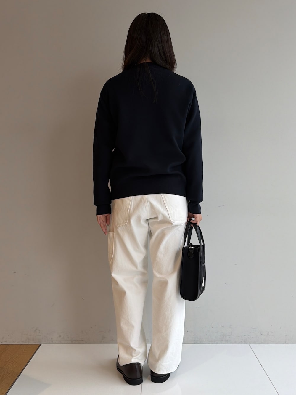 ブルー系のカーディガン/ボレロ、ブラック系のシャツ/ブラウス、ホワイト系のデニムパンツを着用したメンズの秋コーディネートの4枚目の写真