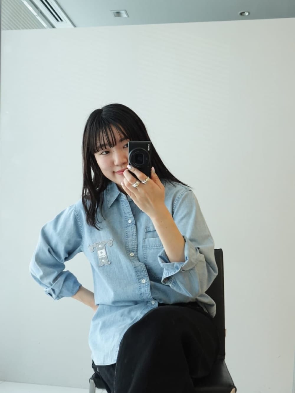ブルー系のシャツ/ブラウス、ブラック系のデニムパンツ、ブルー系のトートバッグを着用したレディースの春コーディネートの4枚目の写真