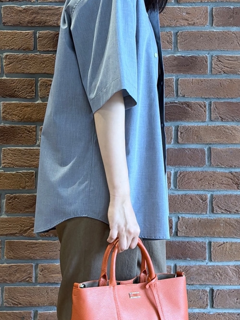ブラック系のポロシャツ、グレー系のシャツ/ブラウス、ベージュ系のスラックスを着用したメンズの夏コーディネートの8枚目の写真