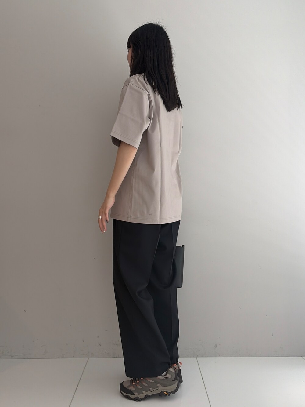 ブルー系のスラックス、ブラック系のトートバッグ、ベージュ系のTシャツ/カットソーを着用したメンズの春コーディネートの2枚目の写真