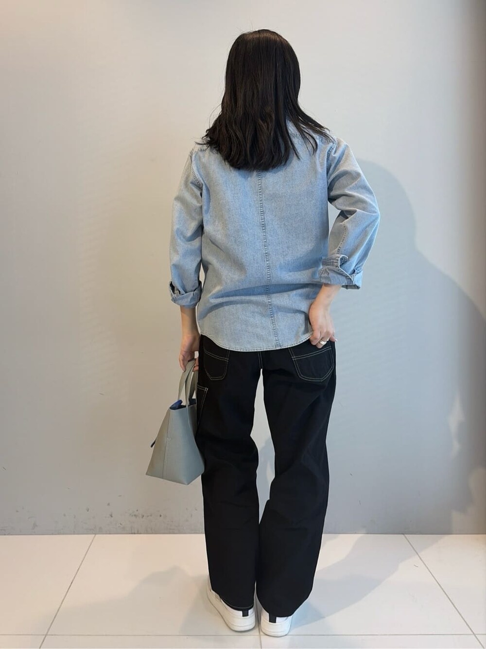 ブルー系のシャツ/ブラウス、ブラック系のデニムパンツ、ブルー系のトートバッグを着用したレディースの春コーディネートの3枚目の写真