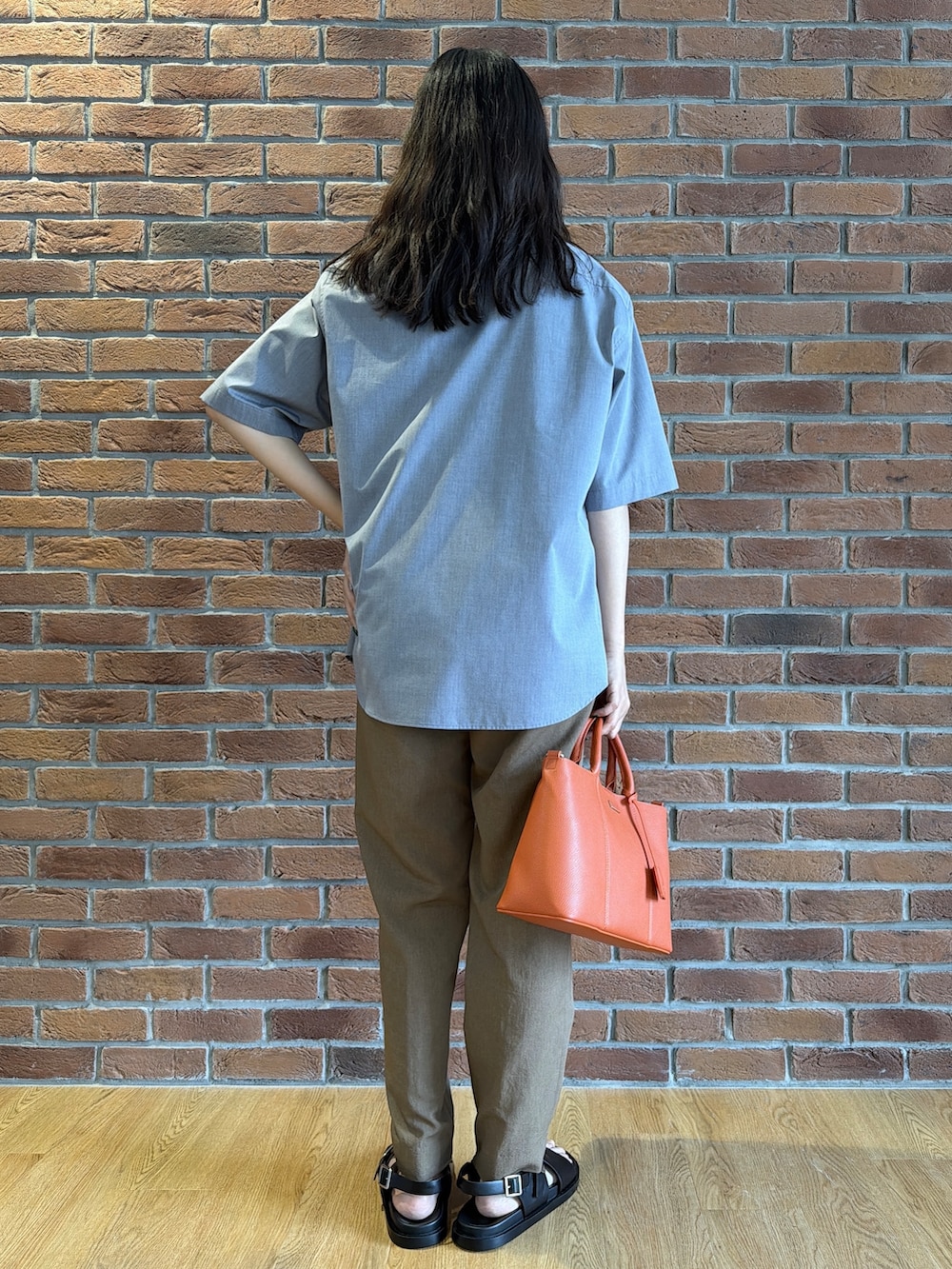 ブラック系のポロシャツ、グレー系のシャツ/ブラウス、ベージュ系のスラックスを着用したメンズの夏コーディネートの4枚目の写真