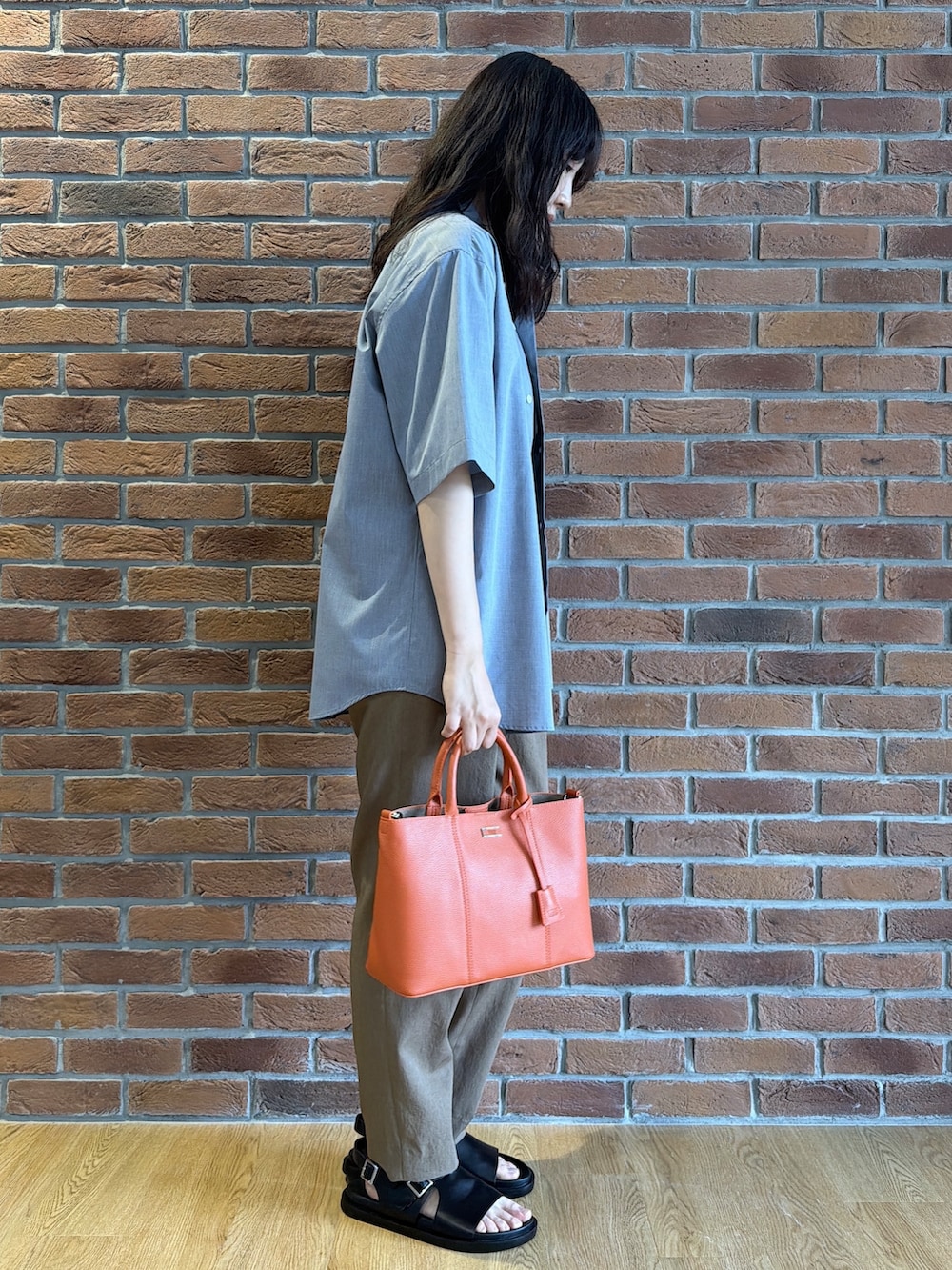 ブラック系のポロシャツ、グレー系のシャツ/ブラウス、ベージュ系のスラックスを着用したメンズの夏コーディネートの2枚目の写真