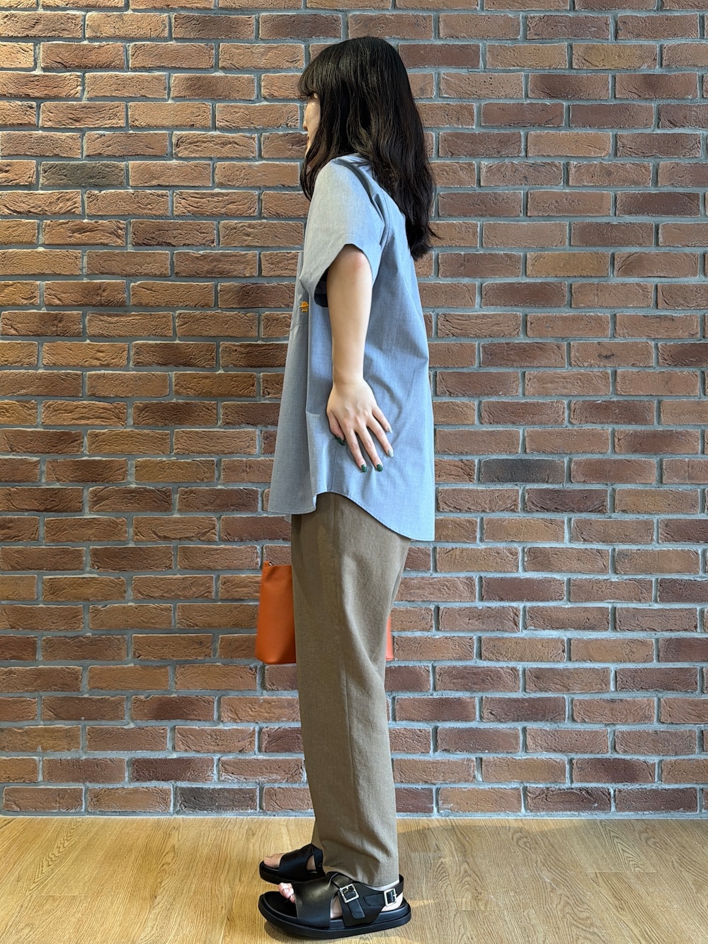 ブラック系のポロシャツ、グレー系のシャツ/ブラウス、ベージュ系のスラックスを着用したメンズの夏コーディネートの4枚目の写真