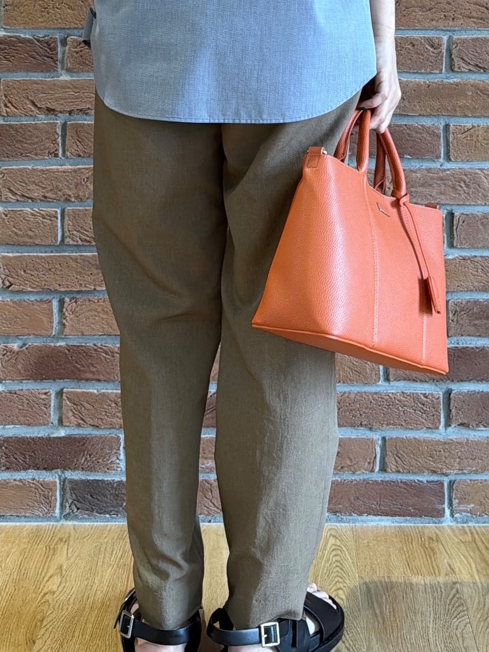 ブラック系のポロシャツ、グレー系のシャツ/ブラウス、ベージュ系のスラックスを着用したメンズの夏コーディネートの7枚目の写真