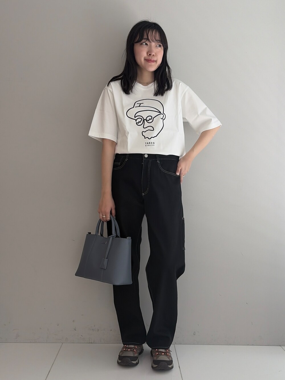 ホワイト系のTシャツ/カットソー、ブラック系のデニムパンツ、ブルー系のトートバッグを着用したメンズの春コーディネートの3枚目の写真