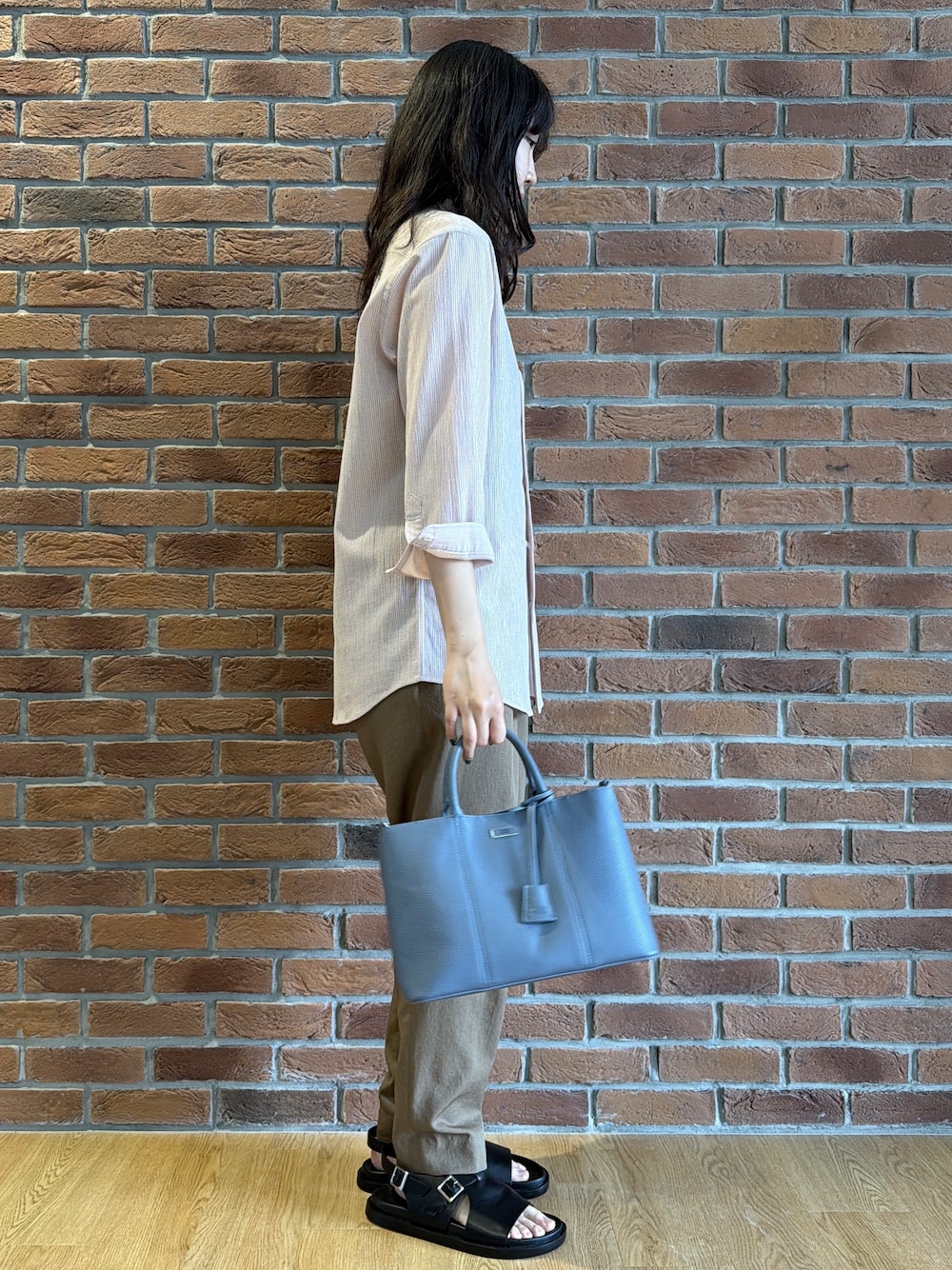 ピンク系のシャツ/ブラウス、ブラウン系のスラックス、ブルー系のトートバッグを着用したメンズの夏コーディネートの2枚目の写真