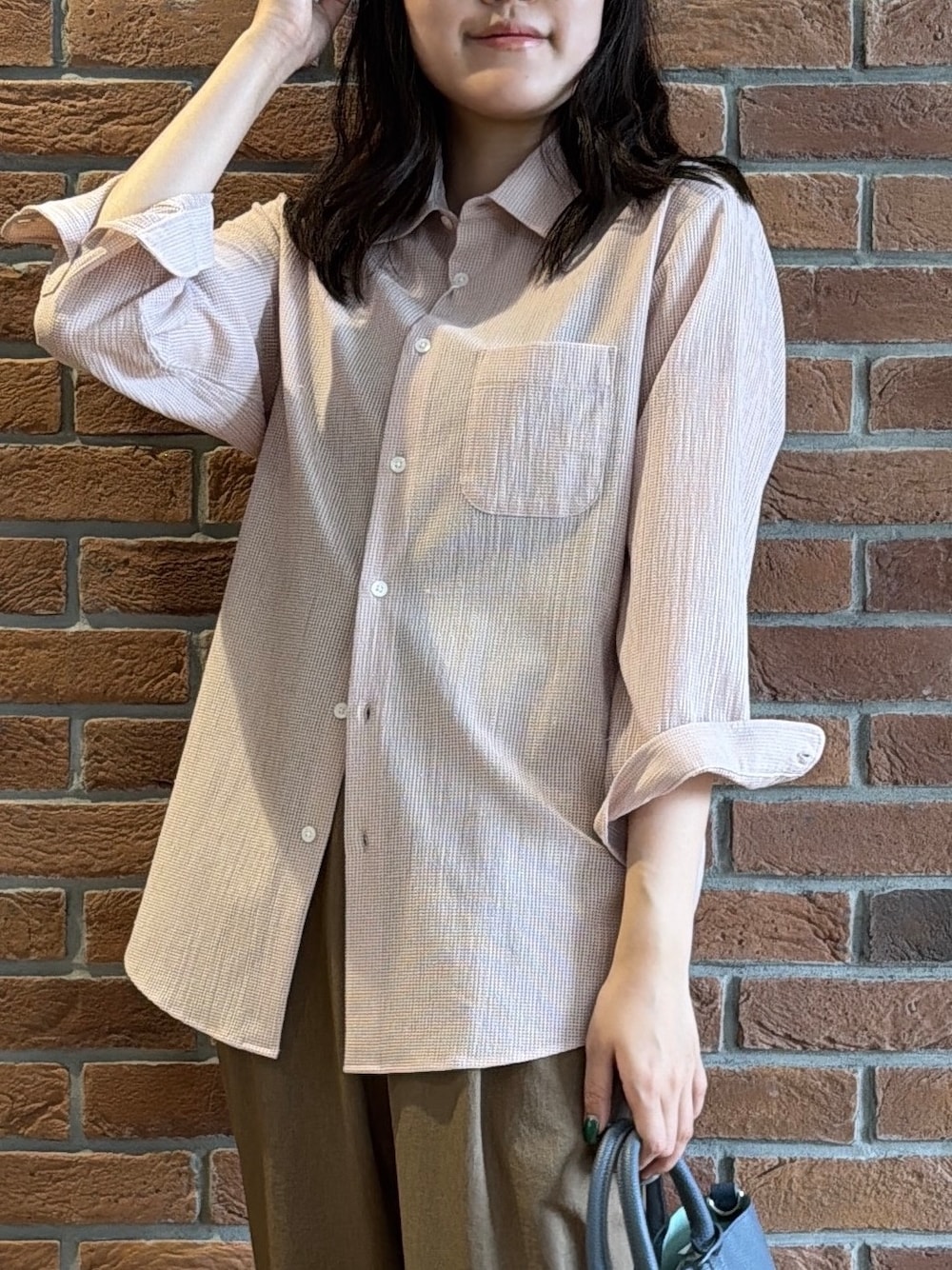 ピンク系のシャツ/ブラウス、ブラウン系のスラックス、ブルー系のトートバッグを着用したメンズの夏コーディネートの6枚目の写真